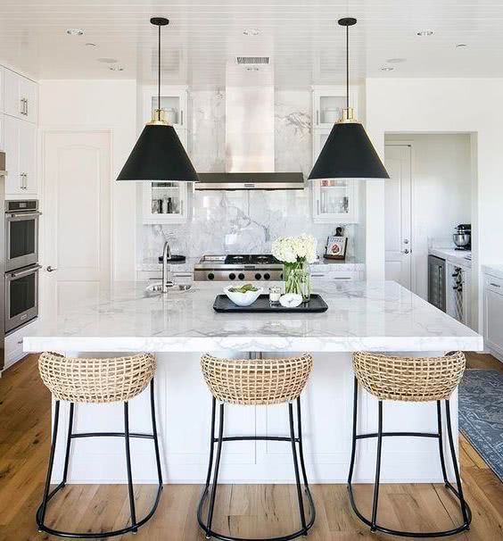 rattan and dark metal stools in black and white kitchen