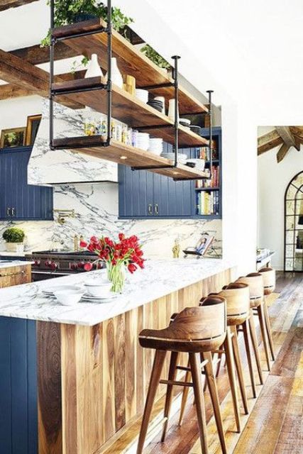 the bar counter is decorated in two different ways blue from the kitchen side and wood from the outside side to match the decor