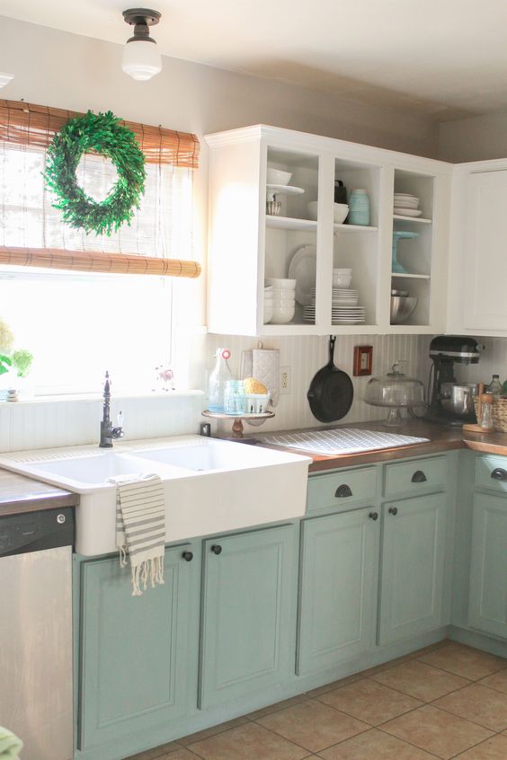 El gabinete de cocina blanco y menta conforman un espacio relajado con un toque vintage