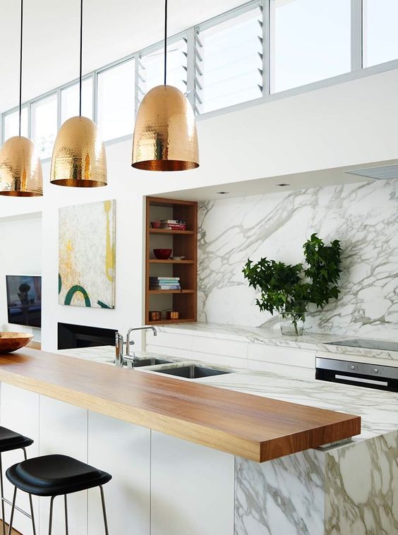 a marble kitchen island is complete with a wooden countertop and a couple of black leather stools