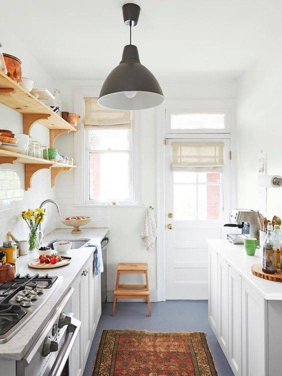 a cozy contemporary kitchen with white cabinets and white stone countertops, open wooden shelves and a printed rug
