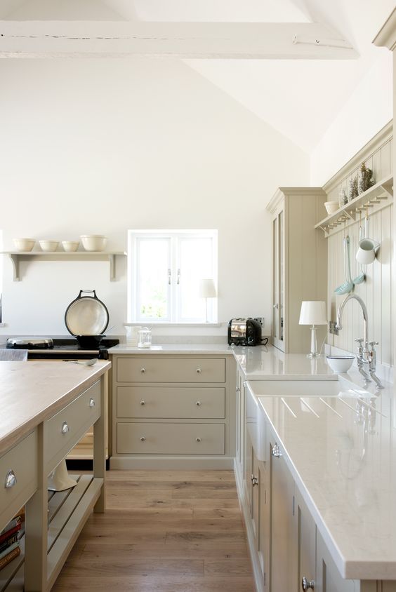 a pretty rustic greige kitchen with shaker cabinets and white stone countertops, a matching planked backsplash and a large kitchen island