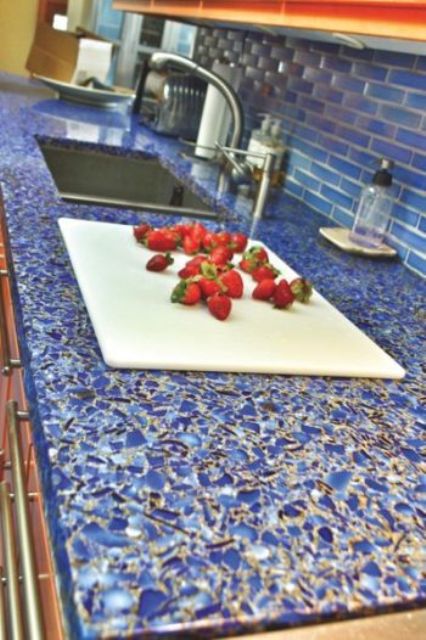 a bright blue mosaic countertop contrasts the warm shade of wood and makes the kitchen bold