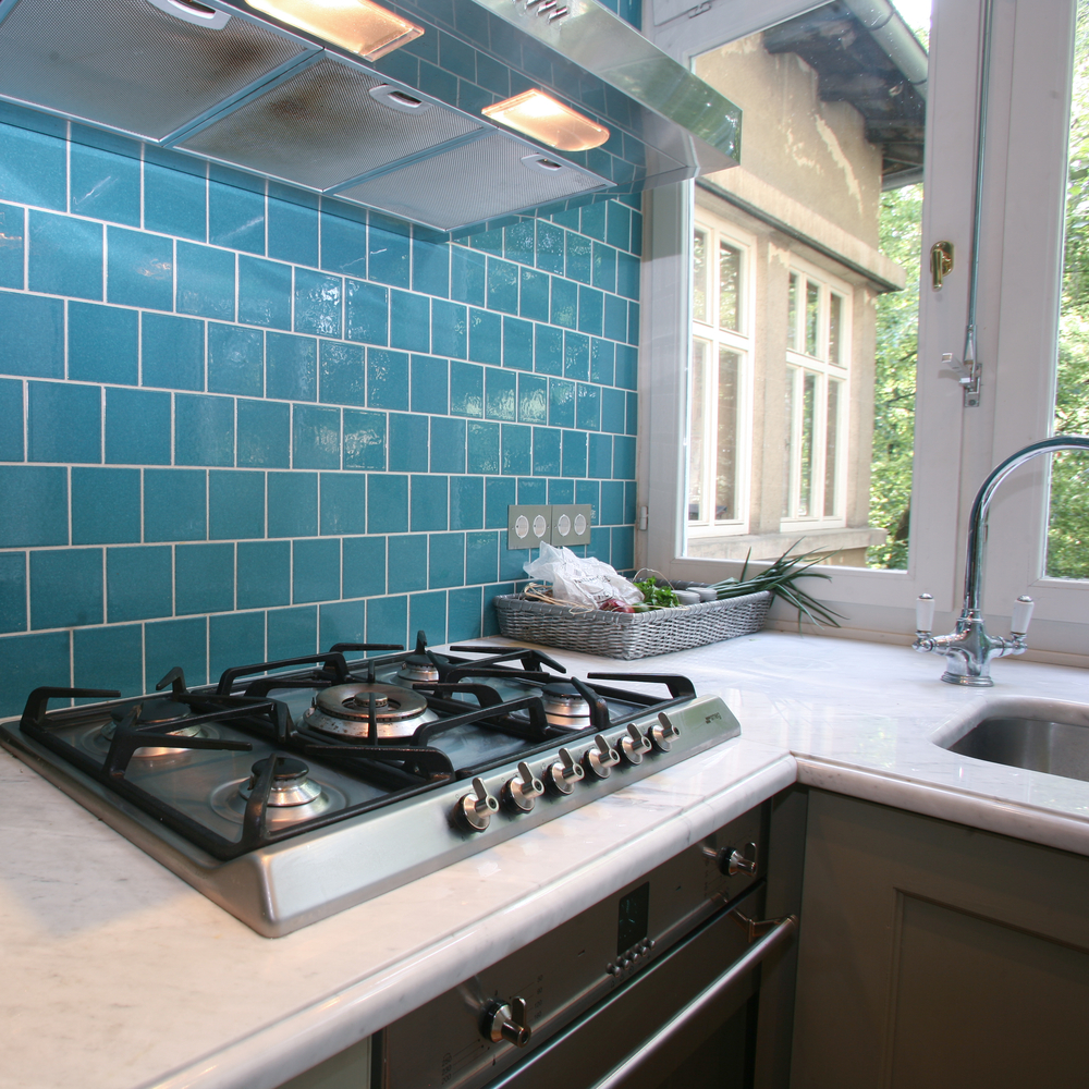 Modern,Kitchen,With,Turquoise,Tiles,On,Wall,Looking,Onto,Garden