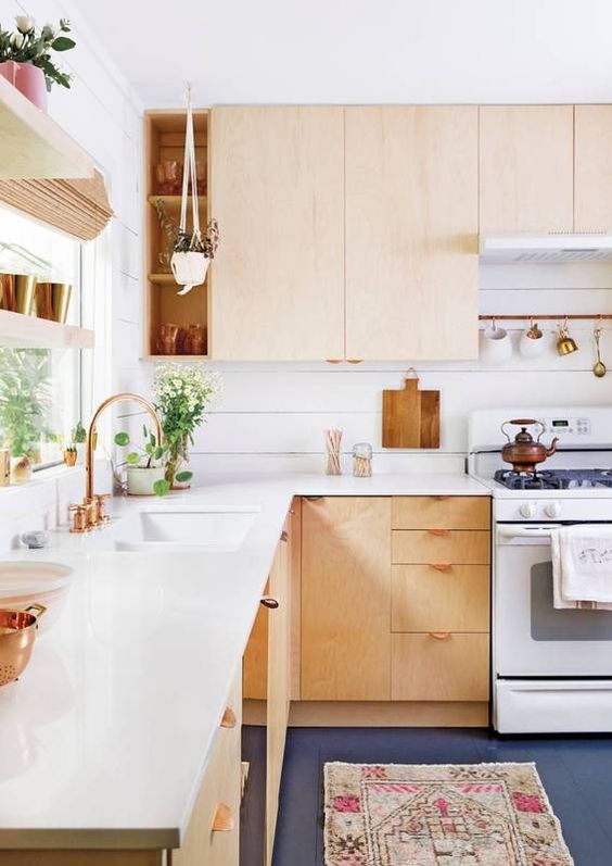a light-colored wooden L-shaped kitchen with copper_yythkg