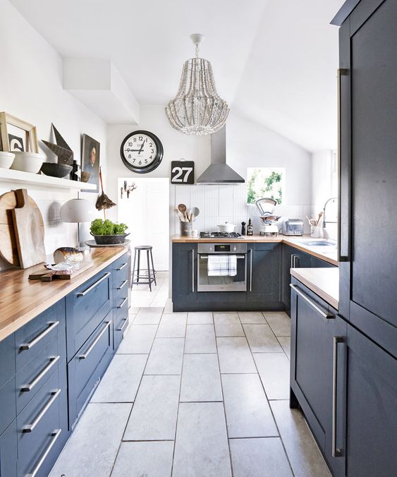 a navy kitchen with butcherblock countertops_ a gre