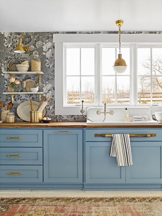 a pretty blue kitchen with a grey floral wal