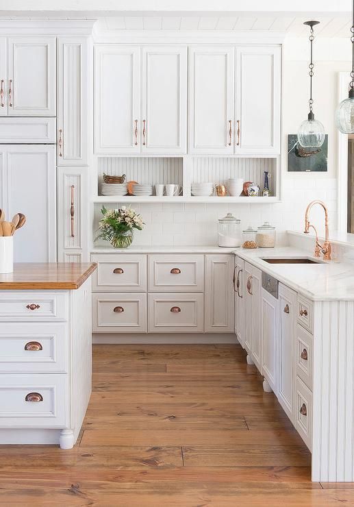 a vintage white kitchen accented with copper hardwa