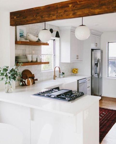 a white L-shaped kitchen spruced up with a w