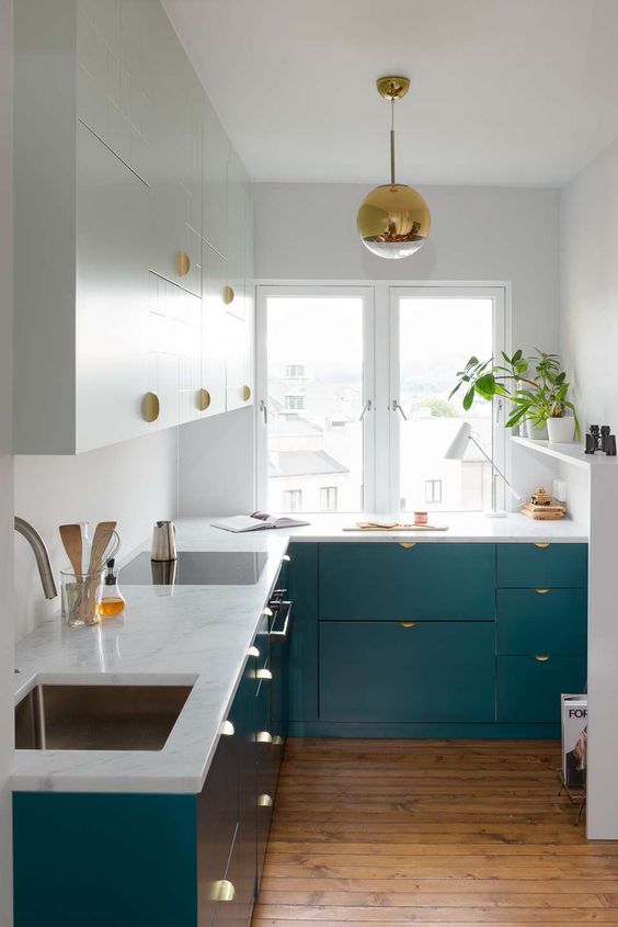 an eye-catchy teal and white kitchen with brass_yyt
