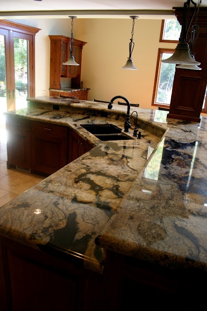 rich stained wooden cabinets and dark stone counter