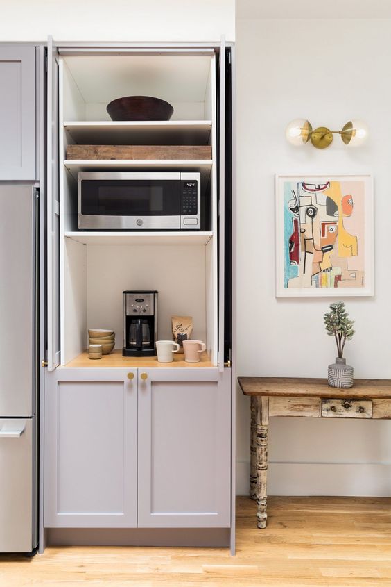 a-cabinet-with-shelves-that-hides-several-appliances-and-creates-a-mini-tea-and-coffee-station-you-m